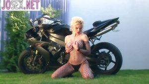 Busty blonde fondles herself on a motorcycle in nylon...